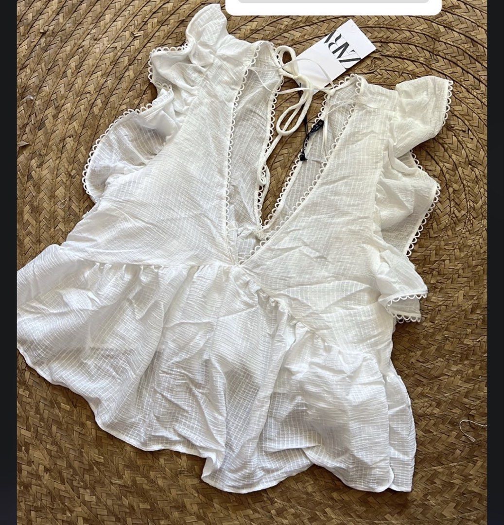 Zara White Ruffle Peplum Top (Category: Blouses) located in Manila. Submitted by southie5 (Listing ID 1467745652, Image 1). Description: - Brand: Zara - Condition: Brand new with tags (never worn out) - Color: Classic white - Style: Sleeveless blouse with deep V-neck and cute tie-back closure - Details: Textured fabric, ruffled shoulders, and a flattering flared peplum hem - Versatility: Perfect to pair with skirts for a dressed-up look or shorts