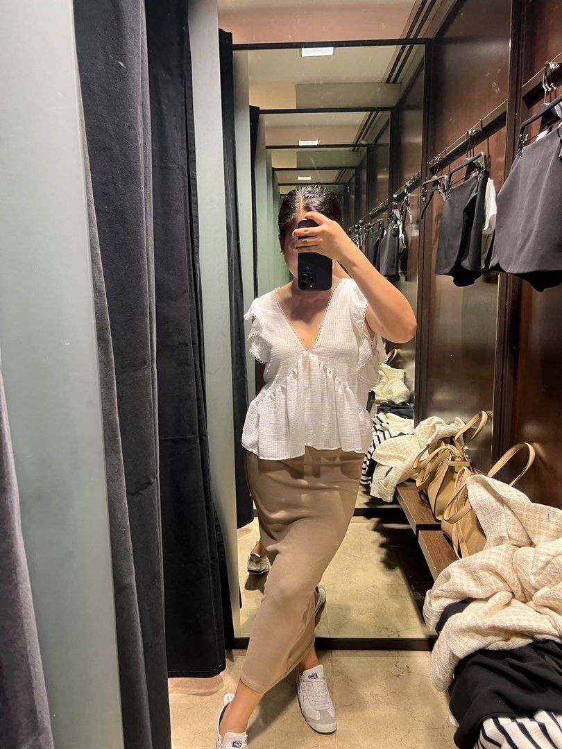 Zara White Ruffle Peplum Top (Category: Blouses) located in Manila. Submitted by southie5 (Listing ID 1467745652, Image 2). Description: - Brand: Zara - Condition: Brand new with tags (never worn out) - Color: Classic white - Style: Sleeveless blouse with deep V-neck and cute tie-back closure - Details: Textured fabric, ruffled shoulders, and a flattering flared peplum hem - Versatility: Perfect to pair with skirts for a dressed-up look or shorts