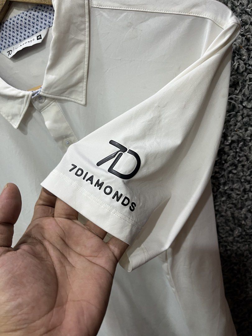 7Diamonds white performance golf polo | Size M (Category: Tshirts & Polo Shirts ) located in General Trias. Submitted by zrchustle.604 (Listing ID 1468055721, Image 3). Description: 7Diamonds white performance golf polo from 7Diamonds, featuring a classic short-sleeve structure, text branding across the left chest, and a patterned detail along the inner collar lining. Known for engineering premium apparel, the brand specializes in 4-way stretch f