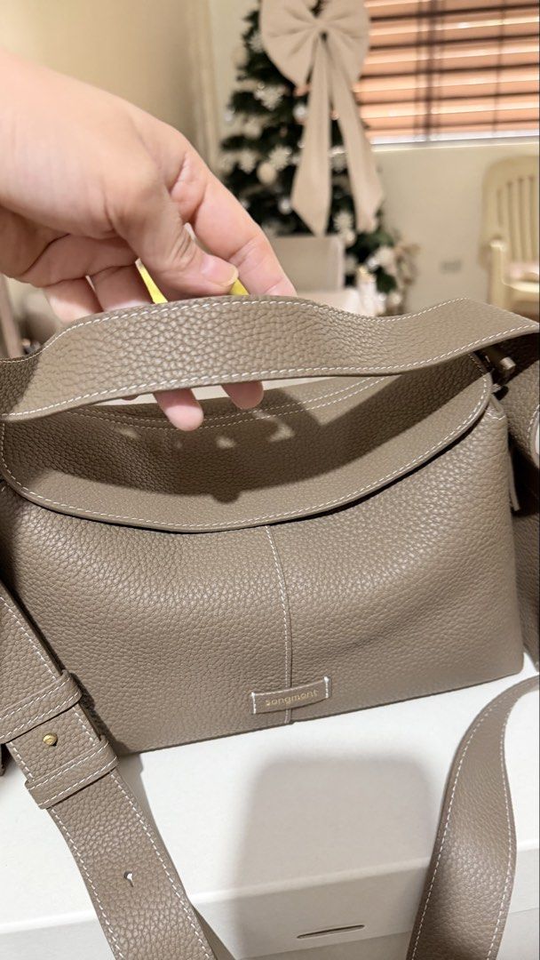 💯 Songmont Drippy Bag❗️ (Category: Cross-body Bags) located in Marikina City. Submitted by barelyshop (Listing ID 1467865330, Image 3). Description: 💯 Authentic Songmont ✨Drippy Bag (Medium) ✨Cow hide leather and in Taupe color ✨In excellent condition and perfect for everyday use. ✨comes with Box, dust bag, Authenticity card and care cards. ✨Perfect for everyday use. ✨Negotiable for serious buyer only.😊.