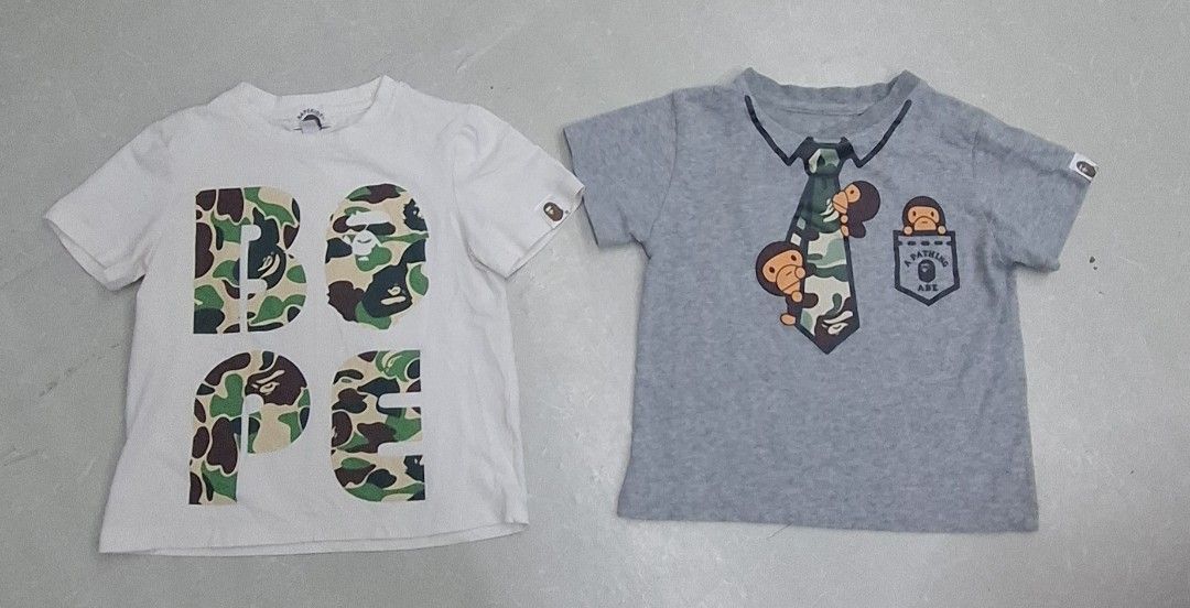 A Bathing Ape Kids T-shirt Bundle (Category: Babies & Kids Fashion) located in Pasay City. Submitted by al1son18 (Listing ID 1467987938, Image 1). Description: - Set of 2 toddler t-shirts from A Bathing Ape (BAPE) Kids line - Includes 1 white shirt with bold camo graphic lettering and 1 grey shirt with a fun printed tie and ape characters - Features signature small ape logo tags on the left sleeve - Crafted from soft, breathable 100% cotton for a