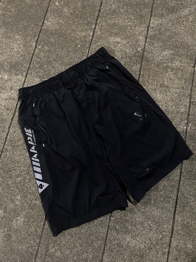 AAPE By A Bathing Ape Black Shorts (Category: Shorts) located in Manila. Submitted by jedgarments0 (Listing ID 1468004725, Image 1). Description: - Brand: AAPE by A Bathing Ape - Color: Black - Fit: Elastic waistband with adjustable drawstring - Design: Large reflective AAPE logo on the right leg, with subtle branding on the left thigh and back - Storage: 2 secure zippered side pockets - Material: Lightweight and breathable fabric - Style: Essent