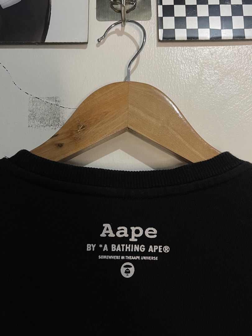 Aape By A Bathing Ape Black Sweatshirt Size M (Category: Coats, Jackets and Outerwear) located in Cabagan. Submitted by blessingma81004 (Listing ID 1467872989, Image 3). Description: - Brand: Aape by A Bathing Ape - Color: Black with big white paint drip logo - Size: Tagged Medium (M) - Material: 100% premium cotton, ribbed cuffs and hem - Details: Signature branding inside collar and back neck DIMENSION: 20 x 25.