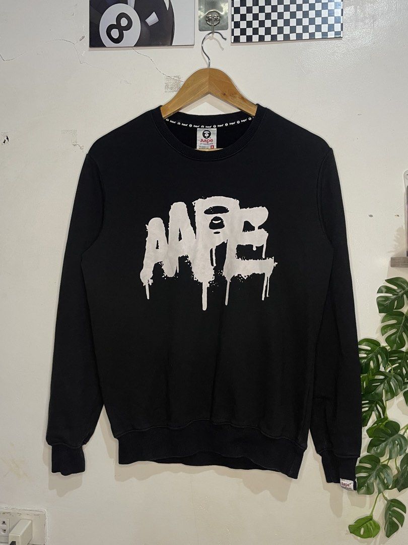 Aape By A Bathing Ape Black Sweatshirt Size M (Category: Coats, Jackets and Outerwear) located in Cabagan. Submitted by blessingma81004 (Listing ID 1467872989, Image 1). Description: - Brand: Aape by A Bathing Ape - Color: Black with big white paint drip logo - Size: Tagged Medium (M) - Material: 100% premium cotton, ribbed cuffs and hem - Details: Signature branding inside collar and back neck DIMENSION: 20 x 25.
