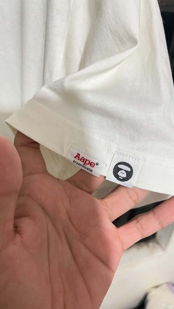 AAPE By A Bathing Ape T-Shirt White (Category: Tshirts & Polo Shirts ) located in Polangui. Submitted by thriftniken (Listing ID 1467886531, Image 3). Description: - Brand: AAPE By A Bathing Ape - Item: White graphic tee with 'AAPE NOW!' circle logo - Size: M - Details: Classic crewneck, short sleeves, signature sleeve hem tag, and branded neck tape - Condition: Clean white fabric, well-maintained - Style: Streetwear / Casual.