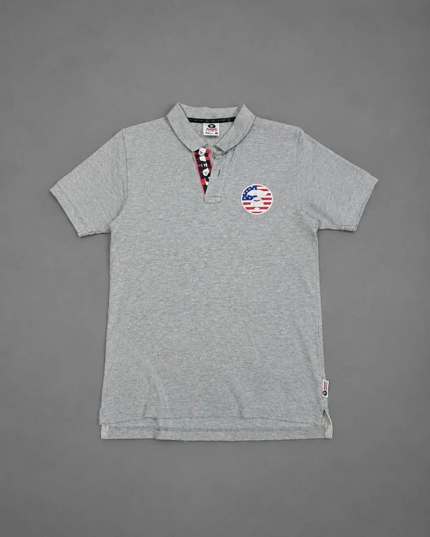 Aape By A Bathing Ape US Flag Patch Polo Shirt (Category: Tshirts & Polo Shirts ) located in Urdaneta. Submitted by jayceegarage (Listing ID 1468026614, Image 1). Description: - Length 25-26 - Width 17.3 - Brand: Aape by A Bathing Ape - Color: Grey - Size: Small - Details: Embroidered American flag ape head patch on chest - Accents: Red, white, and blue patterned fabric lining the button placket - Branding: White text print vertically down the ba