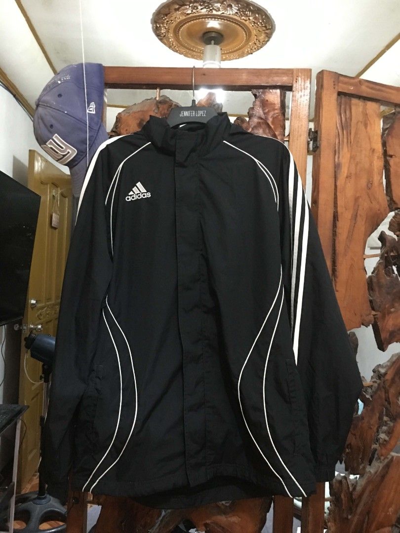 Adidas Black Windbreaker Jacket (Category: Coats, Jackets and Outerwear) located in Manila. Submitted by teo.curated (Listing ID 1467994017, Image 1). Description: Black Adidas windbreaker jacket with a built-in hood. Classic white three stripes down the sleeves plus piping details on the front and back. Full zip front closure. Lightweight material, great outer layer for workouts or daily casual wear. Back features a small white graphic logo near