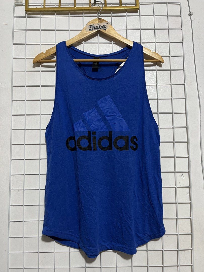 Adidas Blue Athletic Tank Top with S-M (Category: Activewear) located in Pagsanjan. Submitted by zhairaaaaa (Listing ID 1467990020, Image 2). Description: - Brand: Adidas - Color: Bright blue with black logo - Style: Racerback tank top with curved hem - Branding: Large black Adidas logo on front, smaller hit on upper back - Material: Lightweight and breathable fabric - Best for: Workouts, running errands, or casual styling - Condition: Verygood /