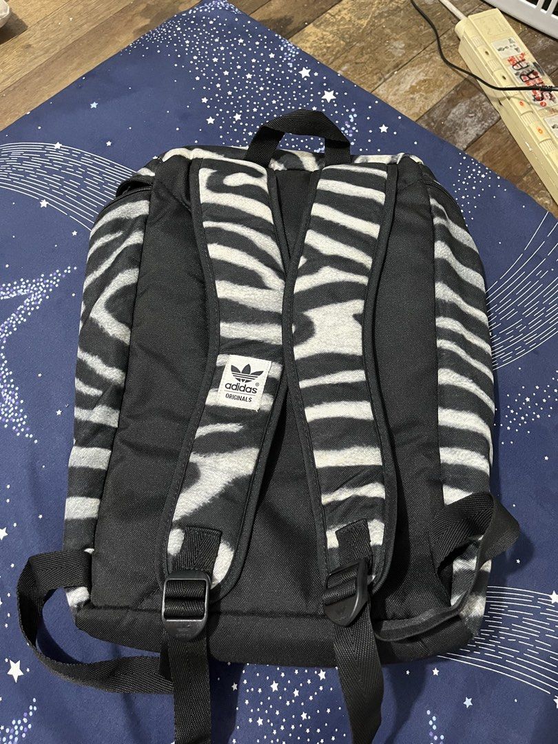Adidas Originals Zebra Print Backpack (Category: Backpacks) located in Pasay City. Submitted by pinedamary44900 (Listing ID 1468050528, Image 2). Description: - Authentic Adidas Originals zebra print backpack - Large white trefoil logo on the front pocket - Zip main compartment with inner slip pocket and blue Adidas branding label - Adjustable shoulder straps with padded backing for comfort - Durable polyester material.