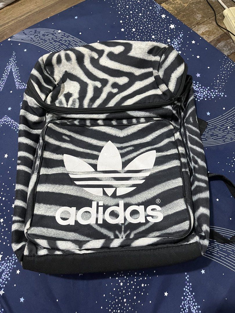 Adidas Originals Zebra Print Backpack (Category: Backpacks) located in Pasay City. Submitted by pinedamary44900 (Listing ID 1468050528, Image 1). Description: - Authentic Adidas Originals zebra print backpack - Large white trefoil logo on the front pocket - Zip main compartment with inner slip pocket and blue Adidas branding label - Adjustable shoulder straps with padded backing for comfort - Durable polyester material.
