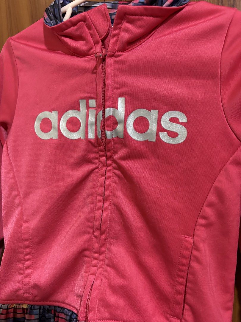 Adidas pink zip-up jacket size 24M (Category: Babies & Kids Fashion) located in Manila. Submitted by wardrobeinmnl (Listing ID 1467841798, Image 2). Description: - Brand: Adidas - Size: 24M (Toddler) - Color: Bright pink with colorful pixelated collar and ruffled hem - Design: Large silver Adidas logo on chest and two front slip pockets - Material: 100% polyester - Condition: Great athletic layer for little ones.