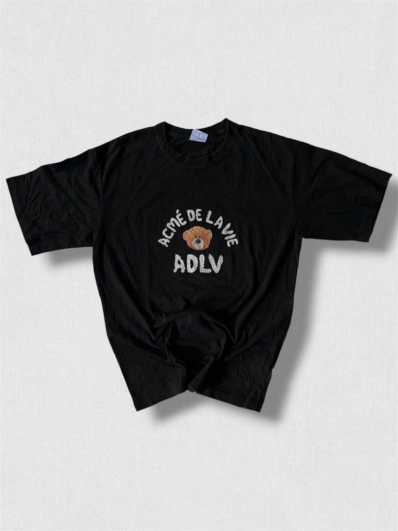 ADLV Bear Print Black T-Shirt (Category: Shirts) located in Cebu City. Submitted by northdrip.threadd (Listing ID 1467903394, Image 1). Description: - Brand: ADLV (Acme De La Vie) - Color: Classic Black - Fit: Relaxed, oversized fit with crew neckline - Design: Small front teddy bear graphic and large back teddy bear print with lettering.