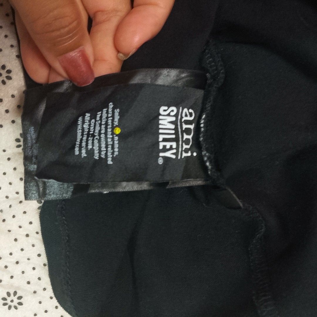 AMI Paris (Alexandre Mattiussi) × Smiley ​ (Category: Tshirts & Polo Shirts ) located in Manila. Submitted by jonahq.9 (Listing ID 1467936788, Image 2). Description: - Brand: AMI Paris (Alexandre Mattiussi) × Smiley ​19x25 dimes - Style: Short-sleeve crew neck tee ​ - Color: Black ​ - Design: Embroidered Smiley face with red AMI heart/beanie on left chest ​ - Fabric: Soft premium cotton ​ - Origin: Made in Portugal (with love) — matches official 