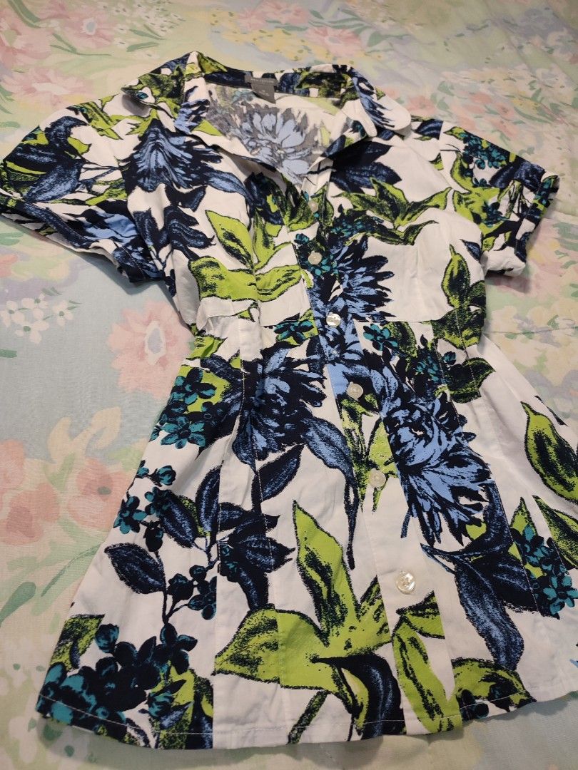 Ann Taylor Floral Short Sleeve Button Down Blouse Size 10 (Category: Blouses) located in Jaen. Submitted by roxantiago (Listing ID 1468038591, Image 2). Description: - Brand: Ann Taylor - Size: 10 (Made in Thailand) - Design: White with blue and green floral leaf pattern, collar, front button closure, and fitted waist - Material: 97% cotton, 3% spandex (comfortable stretch) - Care Instructions: Machine wash cold - Condition: Good wardrobe staple 