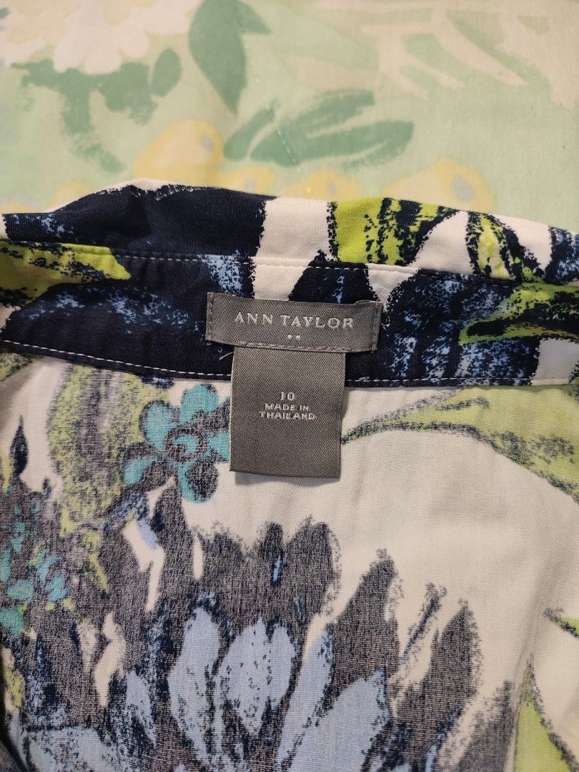 Ann Taylor Floral Short Sleeve Button Down Blouse Size 10 (Category: Blouses) located in Jaen. Submitted by roxantiago (Listing ID 1468038591, Image 3). Description: - Brand: Ann Taylor - Size: 10 (Made in Thailand) - Design: White with blue and green floral leaf pattern, collar, front button closure, and fitted waist - Material: 97% cotton, 3% spandex (comfortable stretch) - Care Instructions: Machine wash cold - Condition: Good wardrobe staple 