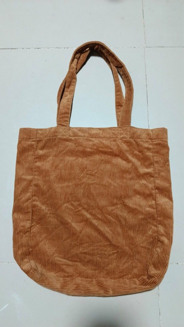 A.P.C. Corduroy Tote Bag (Category: Tote Bags) located in Manila. Submitted by zariyah.1986 (Listing ID 1467964070, Image 3). Description: Brown corduroy tote bag from A.P.C. Rue Madame Paris. Large blue A.P.C. logo stamped on the front. Double shoulder straps with sturdy stitching. Magnetic snap closure at the top opening. Interior slip pockets inside for organization. Soft ribbed fabric texture all over..