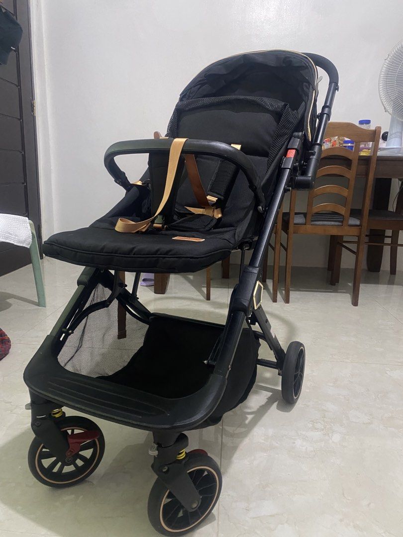 APRUVA AXEL DELUXXE REVERSIBLE COMPACT STROLLER (Category: Strollers) located in Quezon City. Submitted by zhellar (Listing ID 1467900610, Image 2). Description: - Brand: Apruva Stroller - Color: Sleek black with premium gold trim and straps - Canopy: Large canopy for maximum sun protection - Storage: Generous bottom basket for diaper bags and groceries - Safety: Secure harness equipped with comfortable shoulder pads - Mobility: Smooth-rolling wh