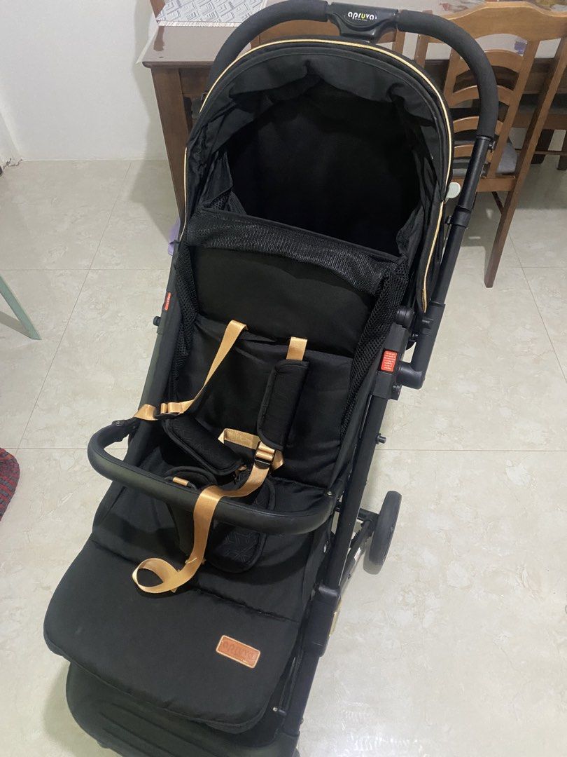 APRUVA AXEL DELUXXE REVERSIBLE COMPACT STROLLER (Category: Strollers) located in Quezon City. Submitted by zhellar (Listing ID 1467900610, Image 1). Description: - Brand: Apruva Stroller - Color: Sleek black with premium gold trim and straps - Canopy: Large canopy for maximum sun protection - Storage: Generous bottom basket for diaper bags and groceries - Safety: Secure harness equipped with comfortable shoulder pads - Mobility: Smooth-rolling wh