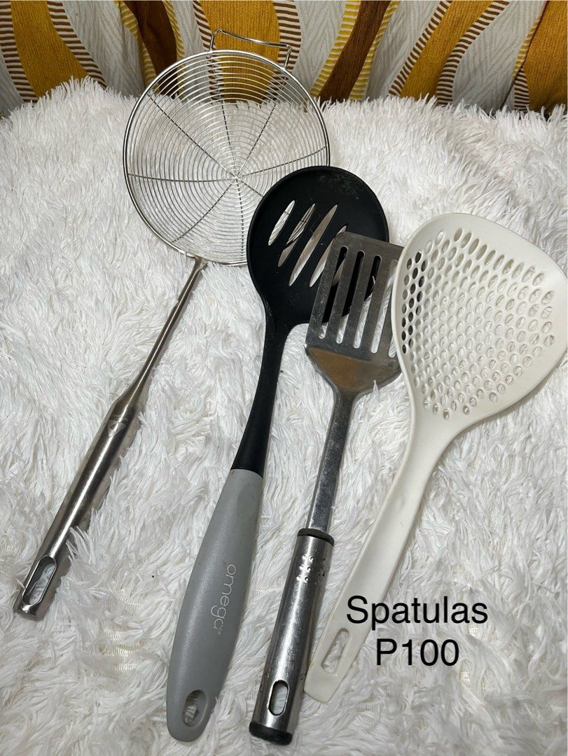 Assorted kitchen utensils spatulas and strainer (Category: Cookware & Accessories) located in Makati City. Submitted by mjaca03 (Listing ID 1467969887, Image 1). Description: - 4-piece kitchen tool bundle for frying and straining - Wire mesh strainer for draining and sifting - Black slotted spoon with Omega branding on the grey handle - Durable metal spatula for flipping and turning - White perforated spoon for scooping and draining - Used utensi