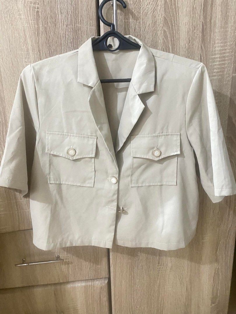 Beige Crop Blazer Short Sleeve with Pockets (Category: Coats, Jackets and Outerwear) located in Quezon City. Submitted by thrifteesph930 (Listing ID 1467845778, Image 1). Description: - Color: Neutral beige - Style: Short-sleeve crop blazer with a boxy cut - Details: Structured lapel collar, single-button center closure, and two chest patch pockets with flap covers and decorative buttons - Material: Lightweight and breathable - Versatility: Easy 