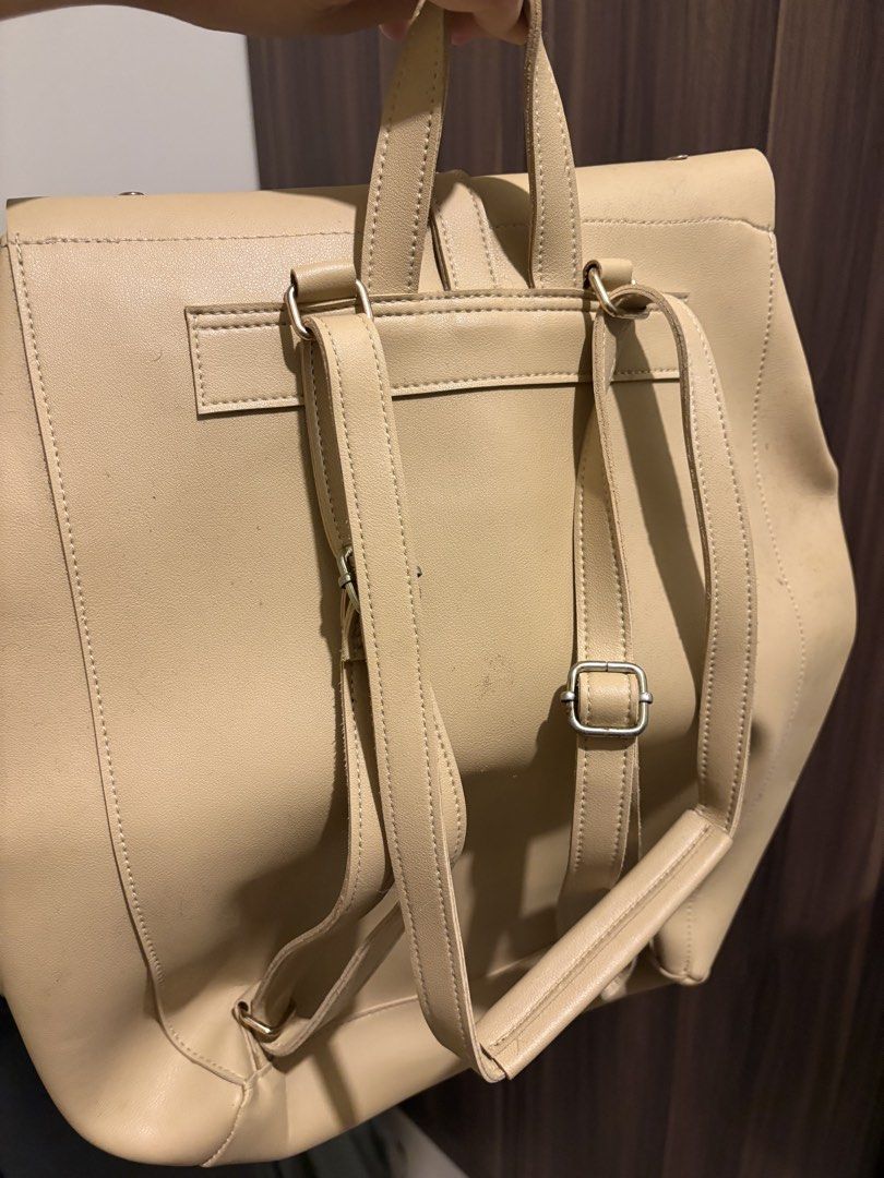 Beige Faux Leather Roll-Top Backpack with Buckle (Category: Backpacks) located in Manila. Submitted by loislane112233 (Listing ID 1468012547, Image 1). Description: Beige faux leather backpack with a roll-top design and front buckle strap closure. Adjustable shoulder straps with metal hardware. Top carry handle attached. Clean minimalist look, neutral tone matches most outfits. Fits daily essentials easily. Some minor scuffs near the bottom front