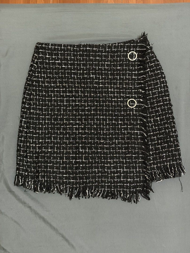 Black and White Tweed Skirt Size M (Category: Skirts) located in Calamba. Submitted by pchyapples (Listing ID 1468028521, Image 1). Description: - Brand: Korean - Made in Italy - Size: M (tag attached) -26-27 waistline - Color/Pattern: Black and white structured plaid tweed with contrast white threading - Style: Wrap-style design with decorative gold-tone ring accents and fringed hem - Interior: Fully lined - Condition: Clean and ready to wear.