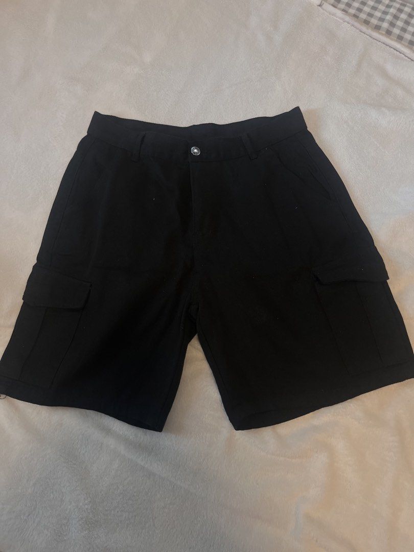 Black Cargo Shorts with Side Pockets (Category: Shorts) located in Manila. Submitted by yliahdreye52249 (Listing ID 1467852140, Image 1). Description: - Color: Classic Black - Style: Casual streetwear - Pockets: Multiple side cargo pockets and two back pockets with a subtle red label detail - Closure: Secure button closure with built-in waistband belt loops - Material: Durable, sturdy fabric designed for daily wear.