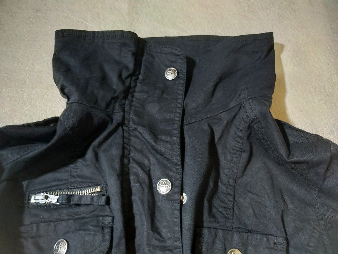 Black Casual Utility Jacket with Pockets (Category: Coats, Jackets and Outerwear) located in Santo Tomas. Submitted by zenzenzennaya (Listing ID 1467991584, Image 3). Description: - Color: Black - Material: Sturdy cotton blend, perfect for cool weather - Design: High collar with front snap buttons - Pockets: Multiple chest pockets including a secure zippered compartment - Sleeves: Roll-up feature with button tabs - Fit: Elasticated hem and cuffs 