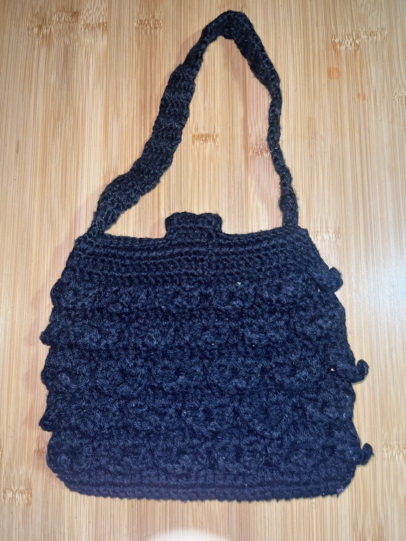 Black Handmade Crochet Shoulder Bag with Floral Button (Category: Shoulder Bags) located in San Pedro. Submitted by eveybiz (Listing ID 1467890905, Image 2). Description: - Handmade black crochet handbag with a unique textured stitch pattern - Features a single strap design for easy shoulder wear - Flap closure secured with a vibrant yellow and orange decorative flower button - Lightweight, small, and convenient for daily essentials - Mode of Pay
