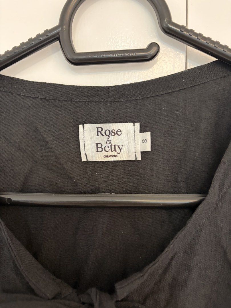 Black Ribbon Tie Blouse (Category: Blouses) located in Quezon City. Submitted by prelovedbynxkole (Listing ID 1467884857, Image 2). Description: - Brand: Rose & Betty Creations - Size: S (tag attached) - Color: Black - Details: Short puffy sleeves, open front with two fabric tie bows, peplum hemline, relaxed fit - Material: Lightweight fabric - Condition: Worn once for a mirror selfie, practically untouched/like new ALL CLOTHES NEED TO BE WASHED 