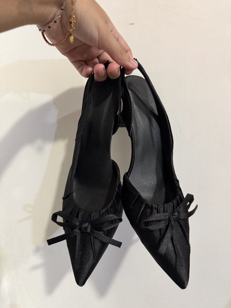 Black Slingback Heels with Bow Detail (Category: Heels) located in Quezon City. Submitted by m.angelaaa (Listing ID 1467901241, Image 1). Description: - Color/Material: Classic black satin fabric with clean soles - Design: Pointed toe with elegant pleated gathering and a cute front bow - Style: Slingback strap with a versatile neutral finish that matches many outfits - Comfort: Comfortable.