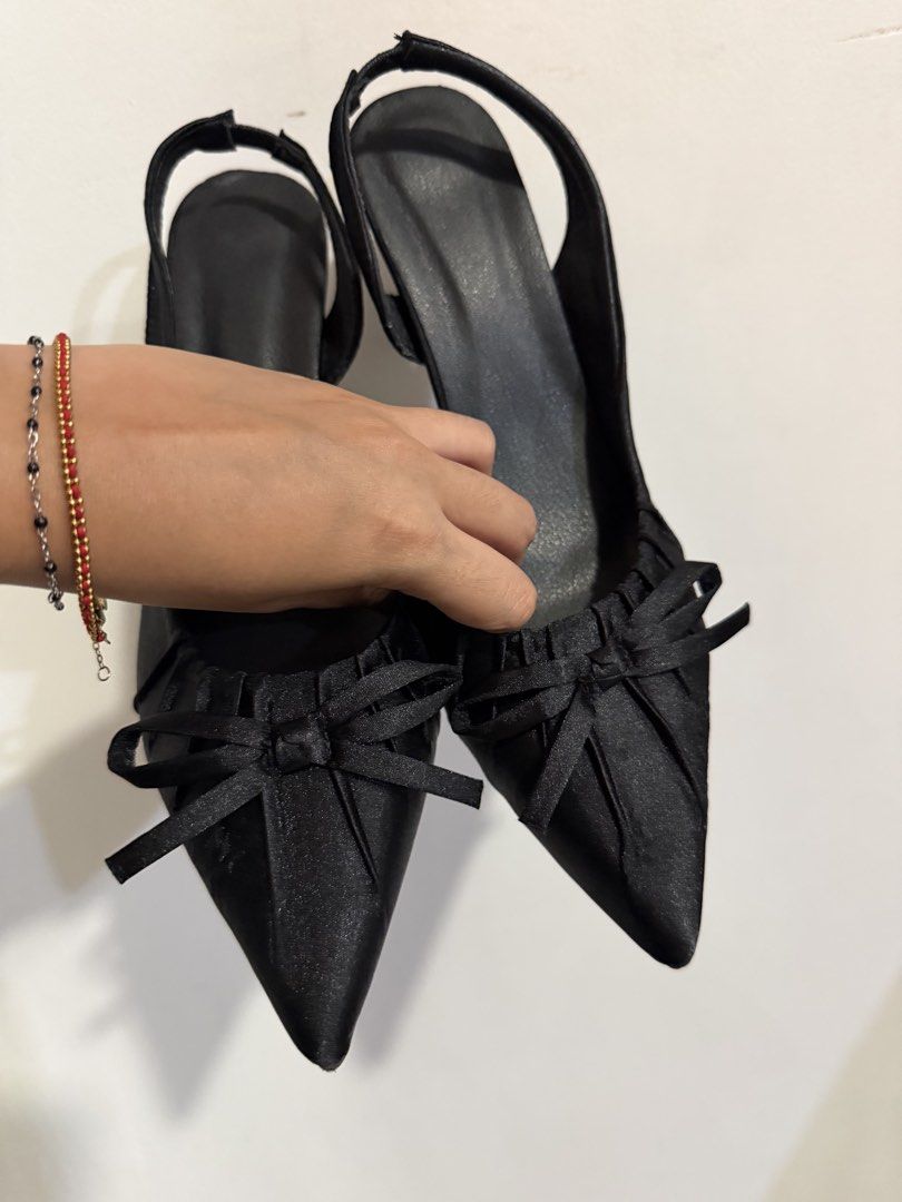 Black Slingback Heels with Bow Detail (Category: Heels) located in Quezon City. Submitted by m.angelaaa (Listing ID 1467901241, Image 3). Description: - Color/Material: Classic black satin fabric with clean soles - Design: Pointed toe with elegant pleated gathering and a cute front bow - Style: Slingback strap with a versatile neutral finish that matches many outfits - Comfort: Comfortable.