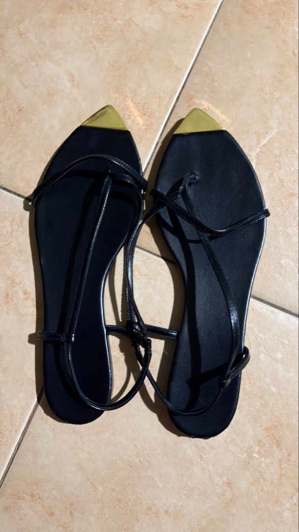 Black strappy sandals with gold toe caps (Category: Flats & Sandals) located in Cebu City. Submitted by eynjlin (Listing ID 1468010038, Image 1). Description: - Color: Classic black with metallic gold accents - Design: Minimalist flat sandals with delicate thin straps and ankle wraps - Statement Toe: Sharp metallic gold pointed toe caps - Comfort: Flat soles ideal for all-day walking - Versatility: Perfect for casual daytime outfits or dressed-up