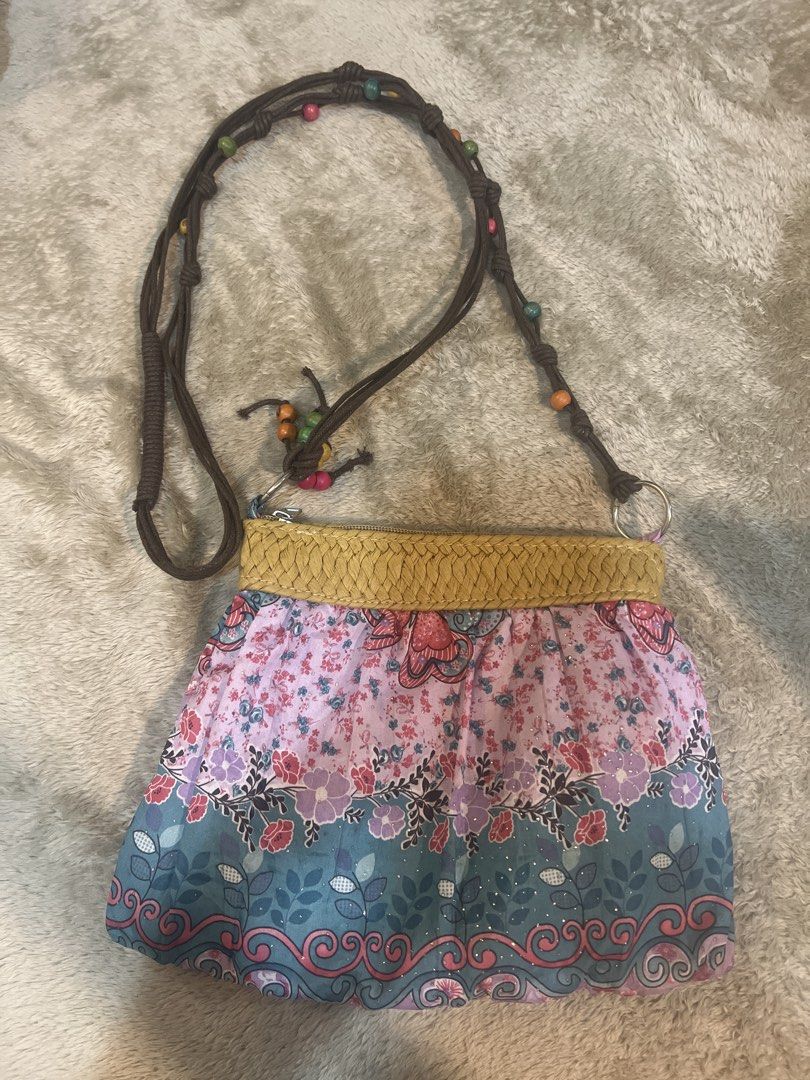 Boho Floral Whimsy Crossbody Bag with Beaded Strap (Category: Cross-body Bags) located in Manila. Submitted by keilonz (Listing ID 1467946919, Image 1). Description: - Style: Boho-chic crossbody bag - Design: Pink and blue floral fabric with mustard yellow braided trim - Strap: Long brown rope strap accented with colorful wooden beads - Closure: Secure top zipper - Perfect for: Casual outings, music festivals, and everyday wear.