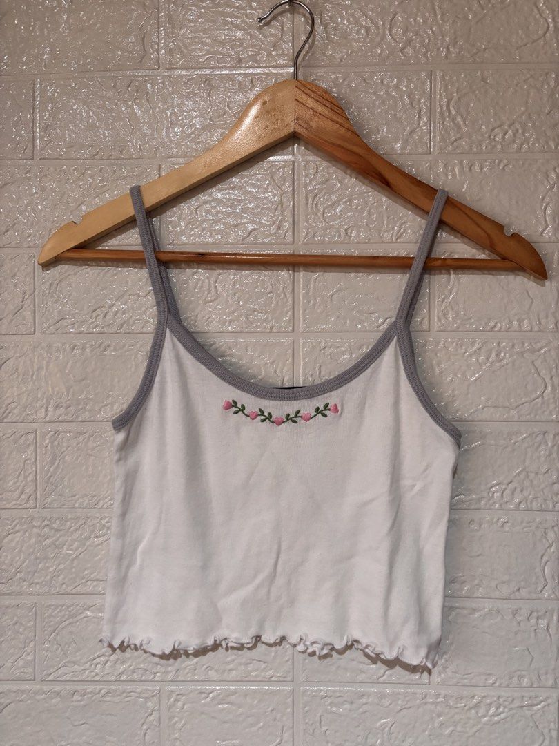 Brandy Melville cami top (Category: Sleeveless) located in Cebu City. Submitted by airahxoxo (Listing ID 1467916497, Image 1). Description: - Brand: Brandy Melville - Style: White camisole tank top with lettuce hem - Details: Grey trim on neckline and straps - Design: Pink heart and green vine embroidery on the chest - Condition: Excellent / Great find! - Mode of Payment: Gcash / BPI - Shipping: Via J&T Express (MMP/Provincial).