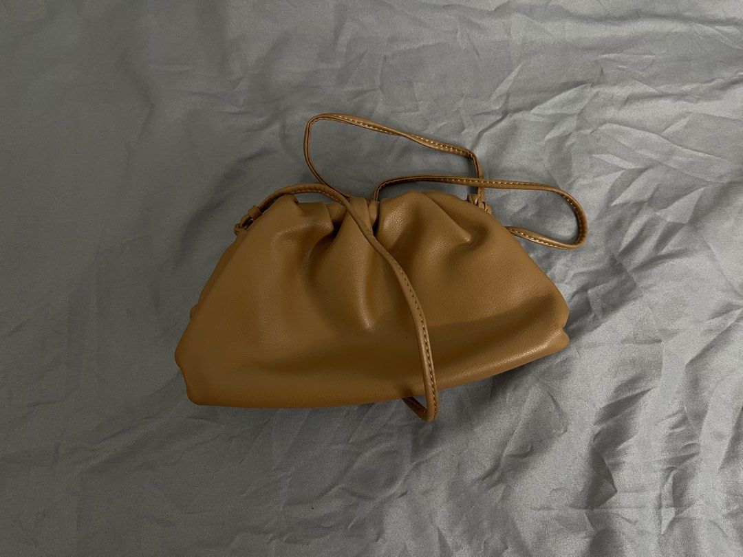 Brown Cloud Pouch Crossbody Bag (Category: Cross-body Bags) located in Imus. Submitted by graeyowl (Listing ID 1467951712, Image 1). Description: - Color: Tan - Material: Soft faux leather - Design: Gathered frame with magnetic closure - Strap: Thin strap for shoulder or crossbody wear - Interior: Clean and spacious for daily essentials - Condition: Some peeling on the inner frame trim from previous use - Style: Neat everyday accessory.
