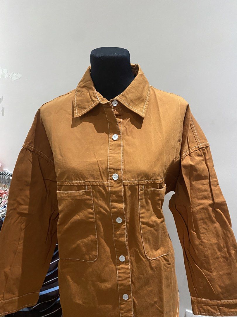 Brown Contrast Stitch Long Sleeve Button Up Shirt Jacket (Category: Coats, Jackets and Outerwear) located in Manila. Submitted by mpt99876 (Listing ID 1467992383, Image 2). Description: - Brown cotton-blend shirt jacket with contrast white stitching - Heavy canvas-like fabric, great for cooler days - Relaxed fit with drop shoulders and pointed collar - Front button closure and two chest pockets - Back yoke with a slight pleat detail for added com