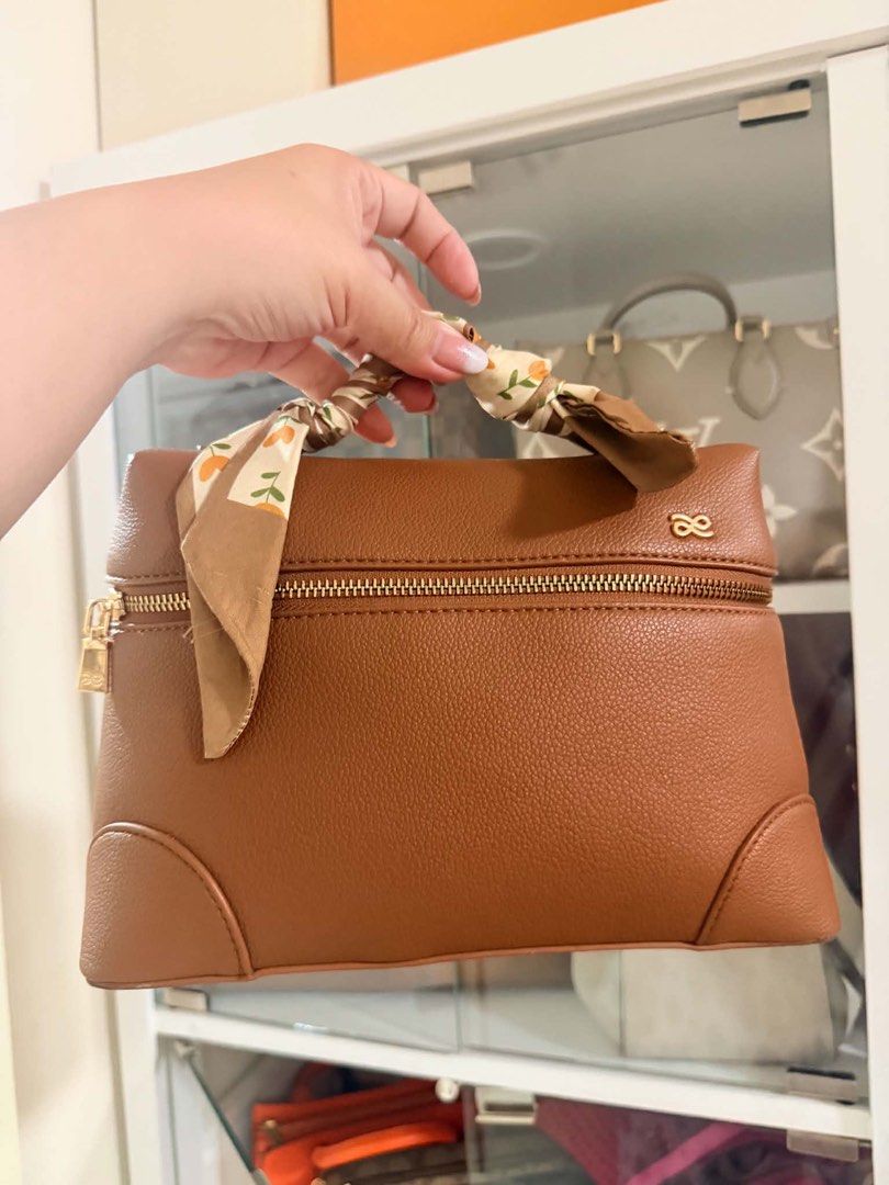 Brown Leather Handbag with Twilly Scarf (Category: Shoulder Bags) located in Manila. Submitted by carlajoyce (Listing ID 1468051165, Image 1). Description: - Color & Finish: Tan brown with a textured leather finish - Hardware: Premium gold-tone zipper and matching accents - Design: Structured everyday silhouette with a compact size - Special Detail: Handle wrapped with a chic patterned twilly scarf featuring orange flower prints - Condition: Bran