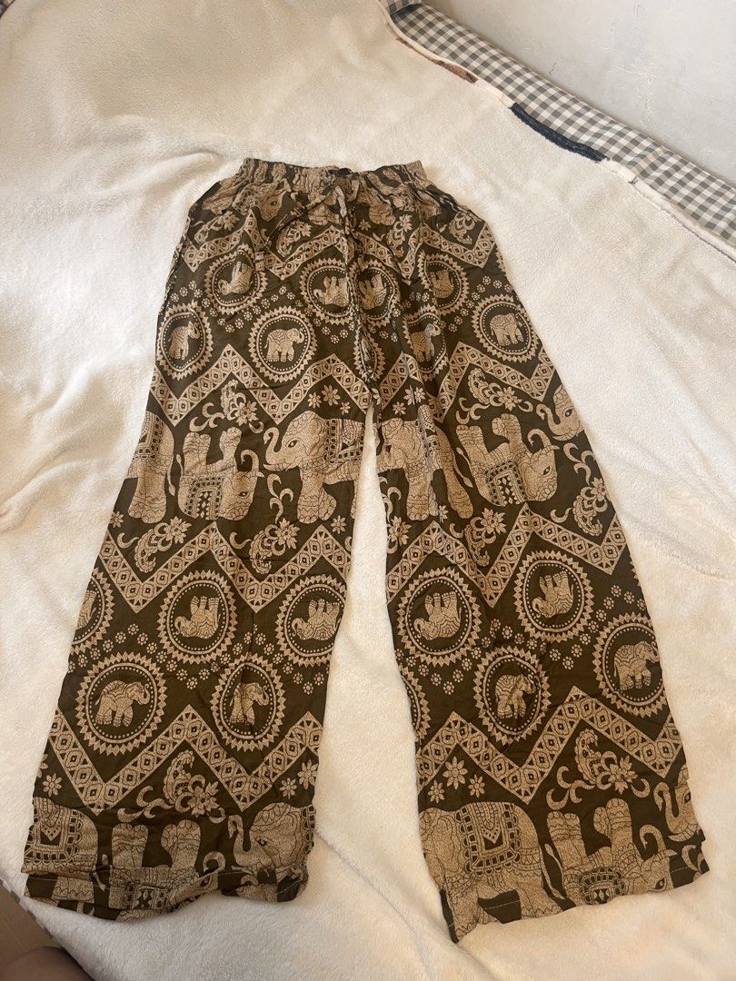 Brown Thai Elephant Print Wide Leg Pants (Category: Jeans) located in Manila. Submitted by yliahdreye52249 (Listing ID 1467852141, Image 1). Description: - Style: Brown wide-leg pants with classic Thai elephant patterns - Fit: Elastic waistband with an adjustable drawstring tie - Material: Lightweight, soft, and flowy fabric for maximum comfort - Versatility: Ideal for lounging, beach days, or casual streetwear - Condition: Great pre-loved condit