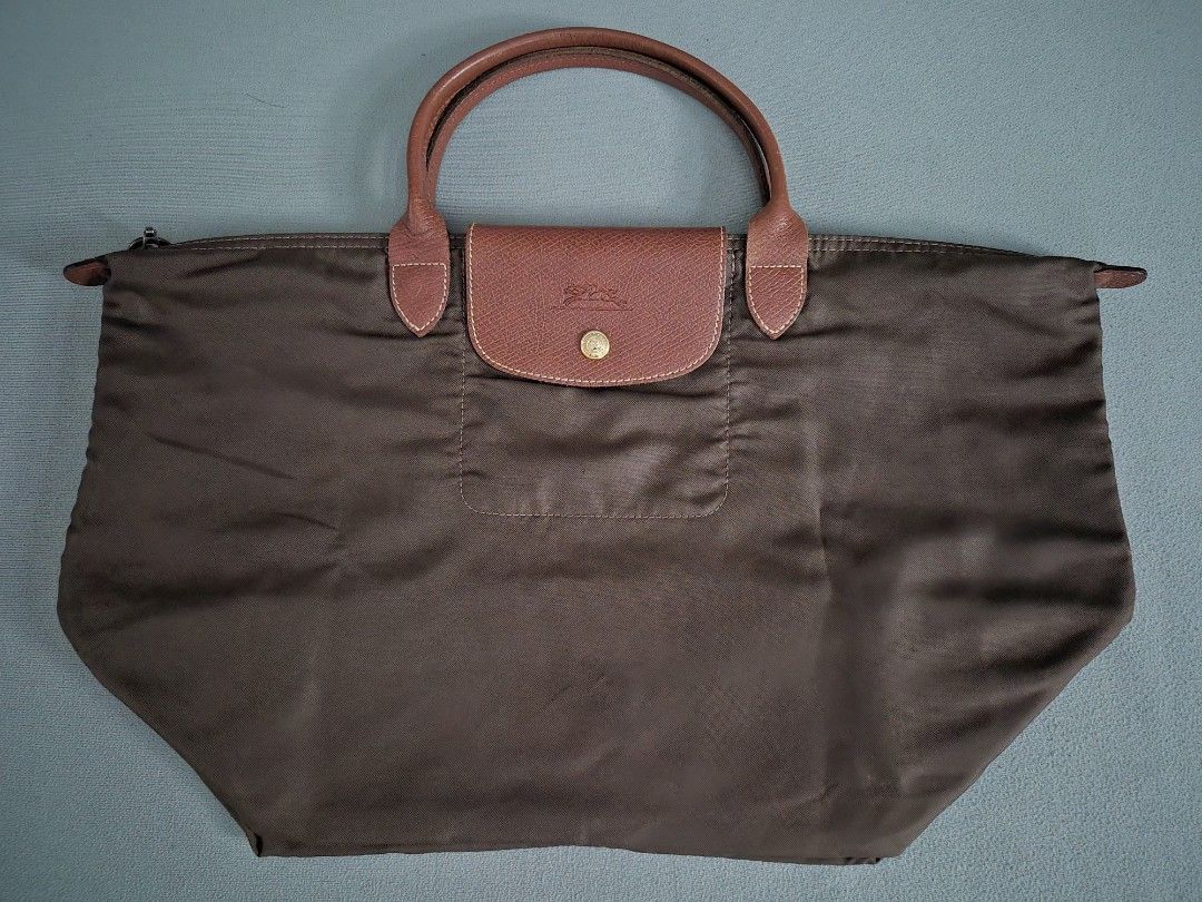 [Bundle] Longchamp Le Pliage Brown Tote Bag Set (2 Sizes) (Category: Tote Bags) located in Quezon City. Submitted by gbabesy2.0 (Listing ID 1467869163, Image 3). Description: - Set of 2 Longchamp Le Pliage short handle bags in classic olive green - Includes one large travel-size tote and one smaller handbag - Durable nylon body with iconic brown leather handles and flap closure - Secure zip top with snap button fastening - Convenient foldable des