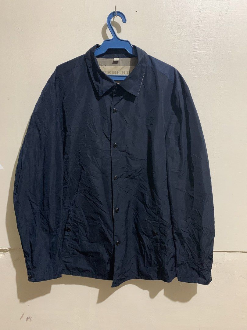 Burberry Brit Navy Blue Jacket Size M (Category: Coats, Jackets and Outerwear) located in Marawi City. Submitted by biidnillah (Listing ID 1467961337, Image 1). Description: - Brand: Burberry Brit - Color: Navy Blue - Size: Medium - Closure: Button-down front with snap buttons - Collar: Features classic check pattern underneath - Interior: Greyish-brown lining with a secure zippered chest pocket - Sleeves: Long sleeves with adjustable button cuff