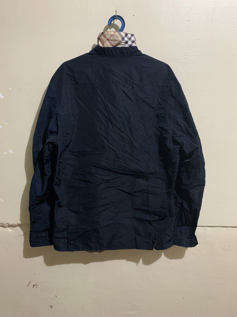 Burberry Brit Navy Blue Jacket Size M (Category: Coats, Jackets and Outerwear) located in Marawi City. Submitted by biidnillah (Listing ID 1467961337, Image 2). Description: - Brand: Burberry Brit - Color: Navy Blue - Size: Medium - Closure: Button-down front with snap buttons - Collar: Features classic check pattern underneath - Interior: Greyish-brown lining with a secure zippered chest pocket - Sleeves: Long sleeves with adjustable button cuff