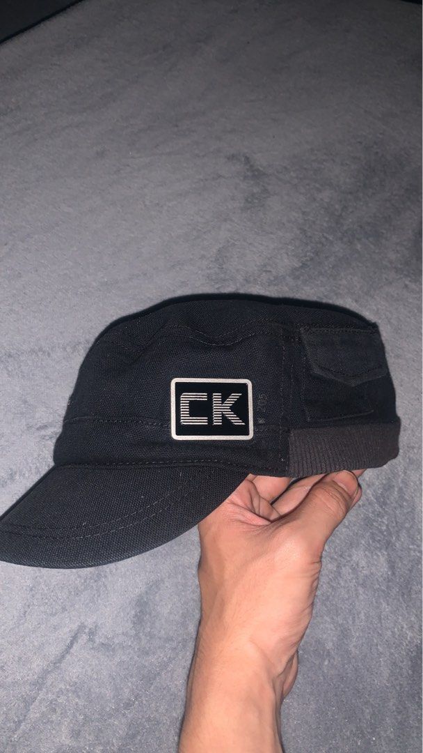 Calvin Klein Black Vintage Cadet Cap (Category: Caps & Hats) located in Angeles City. Submitted by kj772c_ (Listing ID 1468054298, Image 2). Description: - Brand: Calvin Klein - Style: Cadet Cap - Color: Black - Size: One Size - Material: 100% Cotton (Made in Taiwan) - Design details: Embroidered CK logo patch on the side, metal CK plate with graphic on the back - Ventilation: Metallic eyelets for breathability - Comfort: Ribbed band at the base 