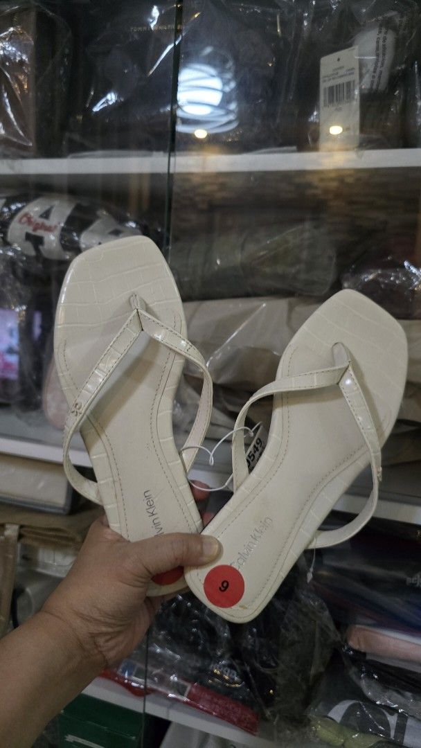 Calvin Klein Cream Thong Sandals (Category: Flats & Sandals) located in Quezon City. Submitted by momof3_11 (Listing ID 1467894754, Image 1). Description: - Brand: Calvin Klein - Style: Thong sandals / Slip-on - Color: Cream - Size: US 6 - Condition: Brand new with original retail tags attached - Details: Croc-embossed texture on straps and footbed, trendy square toe, flat heel - Soles: Clean, unworn condition.