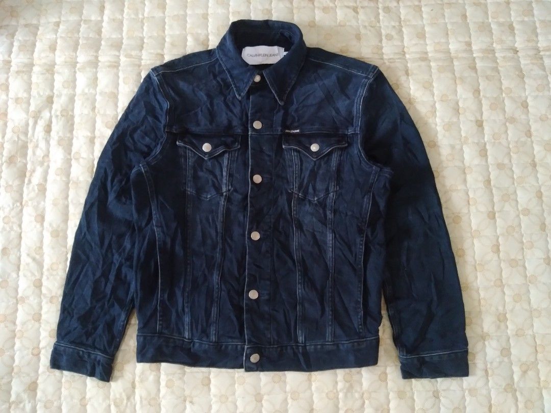 Calvin Klein Denim Trucker Jacket (Category: Coats, Jackets and Outerwear) located in Zamboanga. Submitted by zhumhazhav (Listing ID 1467889259, Image 1). Description: Tag size small Width 20 Length 25 Shoulder 17.5 Sleeve 24 Dark blue color way Spandex/Stretchable fabric Excellent condition Presentable,no flaws Check all photos for details 1450+shipping fee.