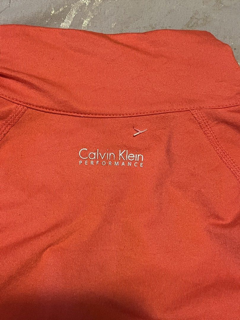 Calvin Klein Performance Orange Zip-Up Active Jacket Size M (Category: Coats, Jackets and Outerwear) located in Cebu City. Submitted by harborclothing29 (Listing ID 1467936198, Image 2). Description: Bright orange Calvin Klein Performance active jacket in size Medium. Features a full front zipper, high collar, ruched pockets, and stretchy fabric. Perfect for workouts and casual wear..