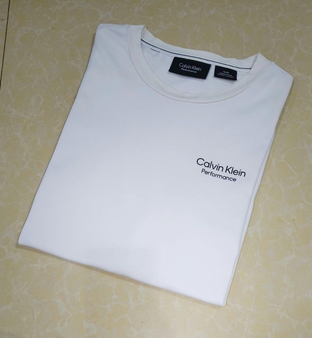 Calvin Klein Performance White T-Shirt XL (Category: Activewear) located in Manila. Submitted by purefire-477a (Listing ID 1467849613, Image 3). Description: - Brand: Calvin Klein Performance - Color: Crisp White - Size: XL (Width: 23 inches, Length: 28 inches) - Design: Minimalist chest logo print, crew neck, short sleeves - Condition: Clean fabric, excellent overall condition - Style: Versatile and easy for everyday wear.