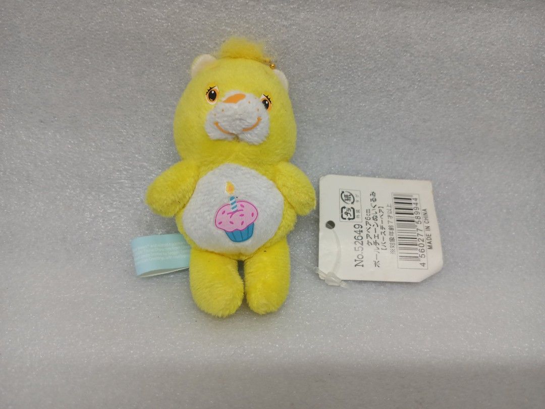 Care Bears Yellow Birthday Bear Plush Keychain (Category: Plushies & Soft Toys) located in Pila. Submitted by Yela.ph_1 (Listing ID 1467947457, Image 2). Description: - Authentic Yellow Care Bears plush keychain - Features a sweet pink cupcake belly symbol with a lit blue candle - Compact size: Measures approximately 6cm tall - Complete with original Japanese hang tag and blue tush tag - Includes a gold ball chain, ready to hang on your bag or ke