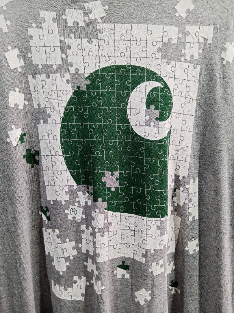 Carousell Graphic T-Shirt Gray Medium (Category: Tshirts & Polo Shirts ) located in Lucban. Submitted by aeronroyyy (Listing ID 1467863643, Image 3). Description: - Color: Gray - Size: Medium - Design: Large green and white puzzle graphic with the iconic Carousell logo on the front - Style: Standard crew neck and short sleeves - Fit: Classic casual tee, ideal for everyday wear.