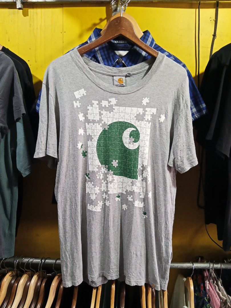 Carousell Graphic T-Shirt Gray Medium (Category: Tshirts & Polo Shirts ) located in Lucban. Submitted by aeronroyyy (Listing ID 1467863643, Image 1). Description: - Color: Gray - Size: Medium - Design: Large green and white puzzle graphic with the iconic Carousell logo on the front - Style: Standard crew neck and short sleeves - Fit: Classic casual tee, ideal for everyday wear.
